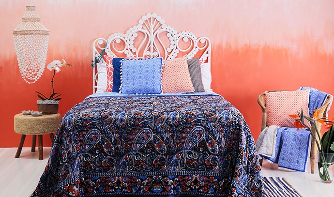 zohi-interiors-bedroom-patterned-covers-blue-pillows-chandelier