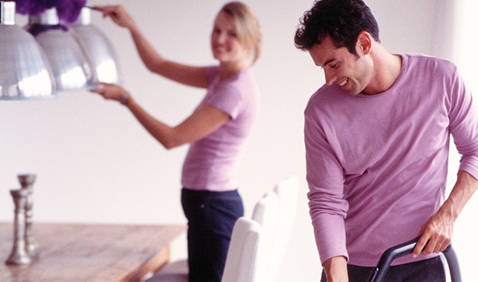 couple-wearing-purple-shirts-cleaning-home-vacuum