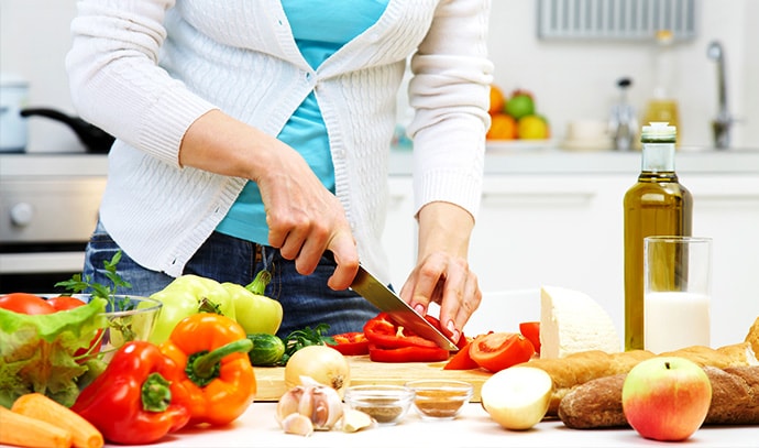 woman-cooking-at-kitchen-slicing-vegetables