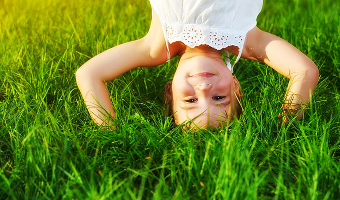 little-girl-smiling-backflip-grass